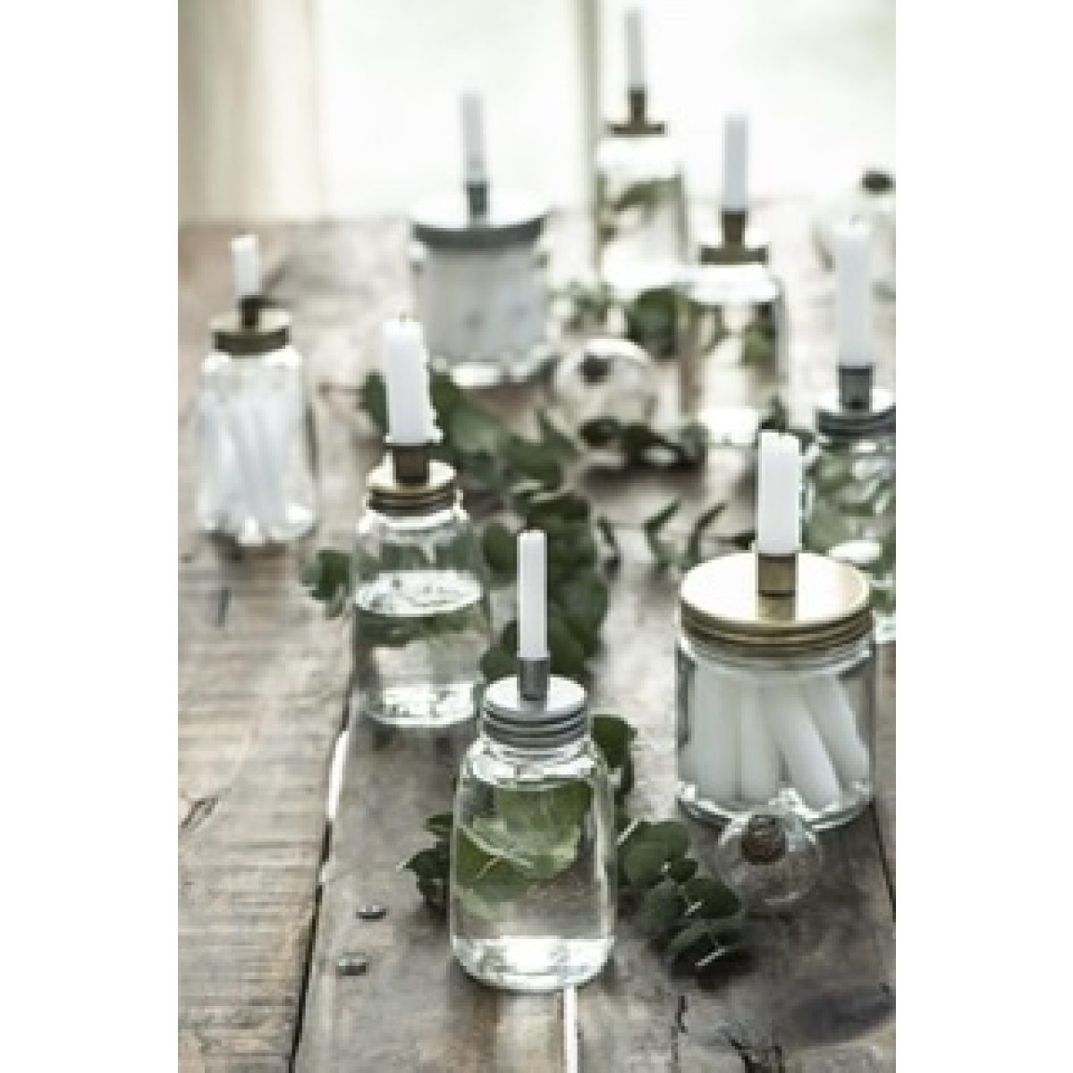 Kerzenhalter auf Glasvasen mit weißen Kerzen